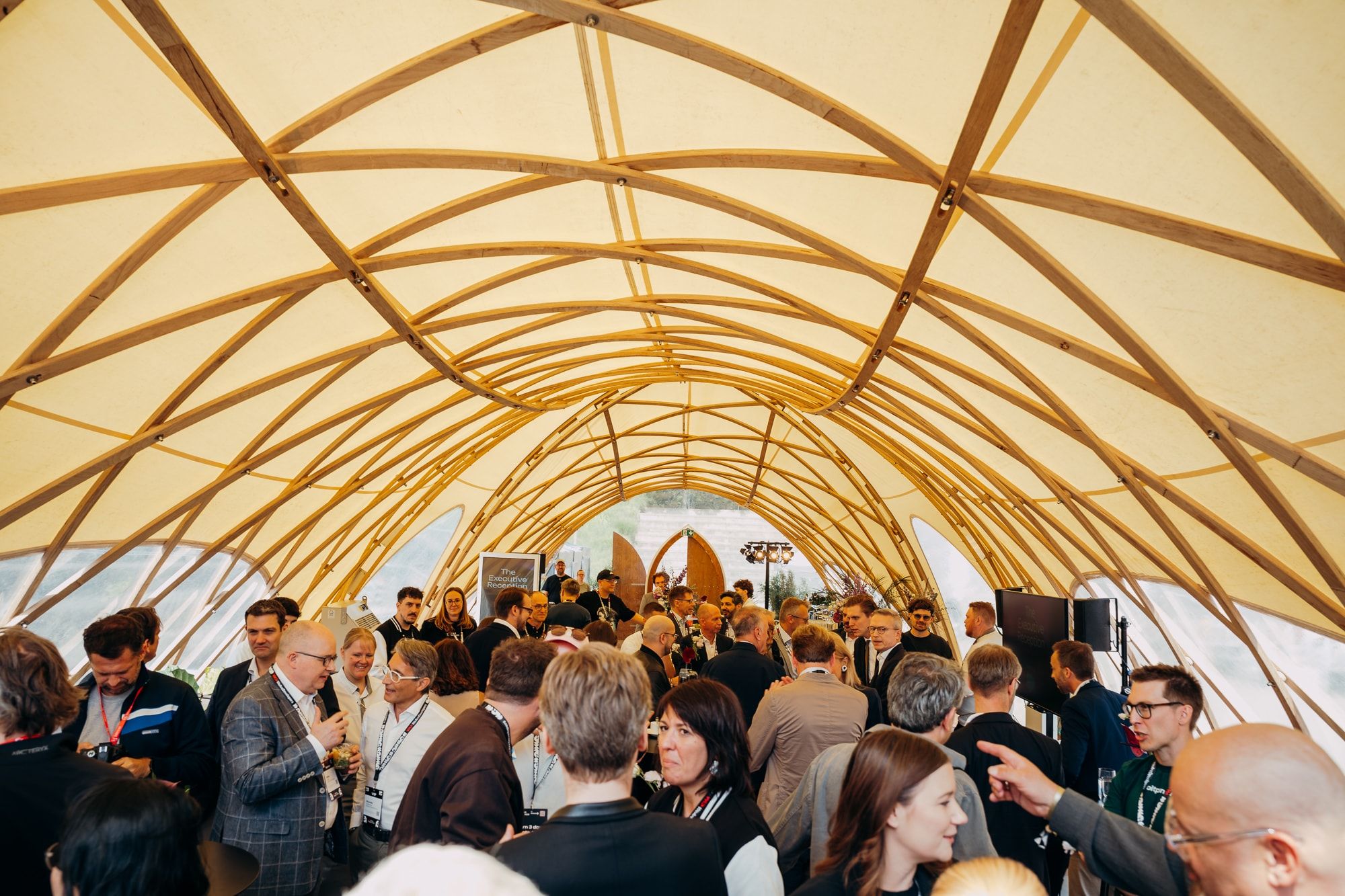 Attendees networking under a wooden canopy in the expo area at WeAreDevelopers World Congress 2026