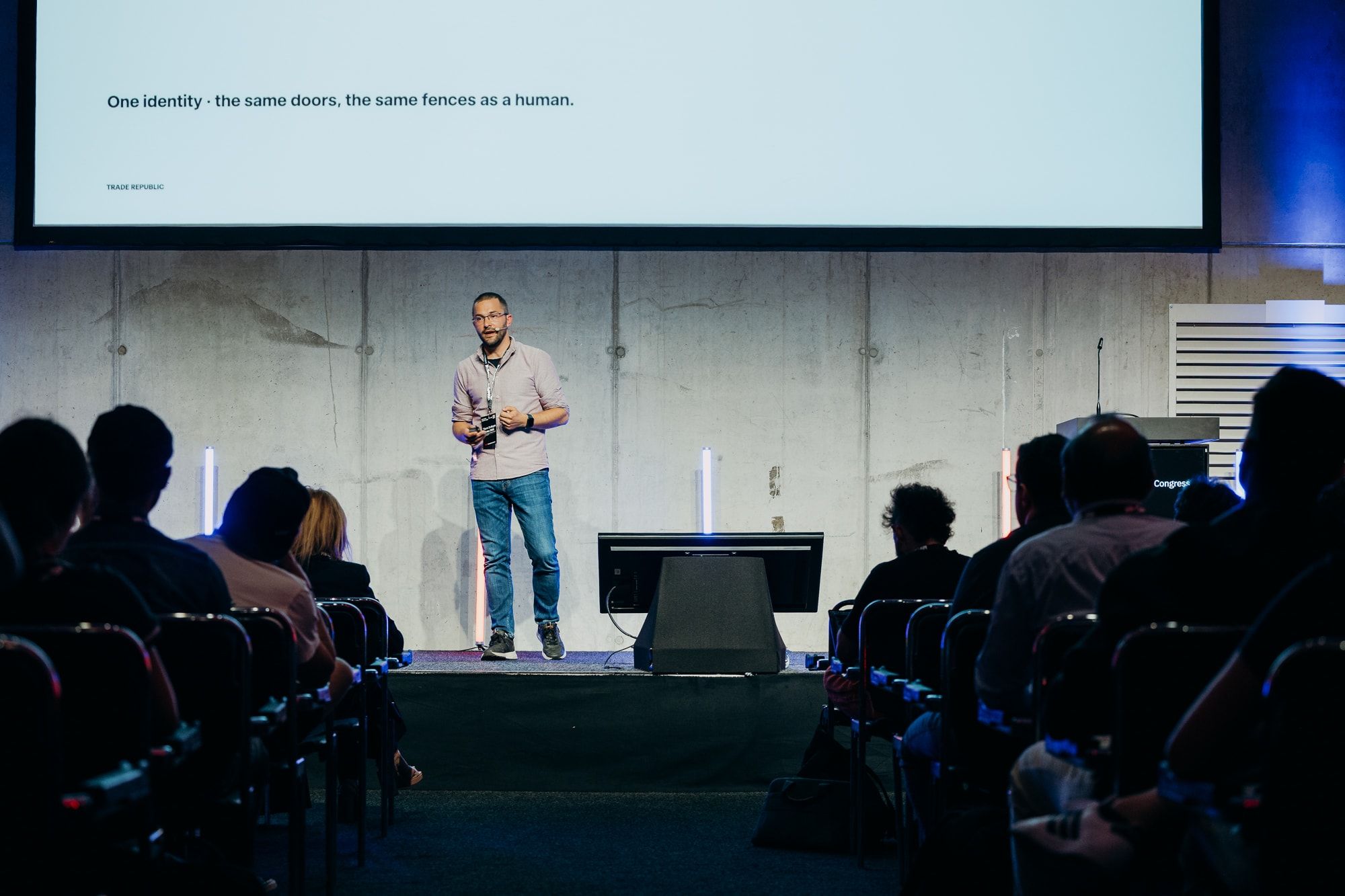 Sasa Fajkovic on stage below a slide reading “One identity – the same doors, the same fences as a human” at WeAreDevelopers World Congress 2026