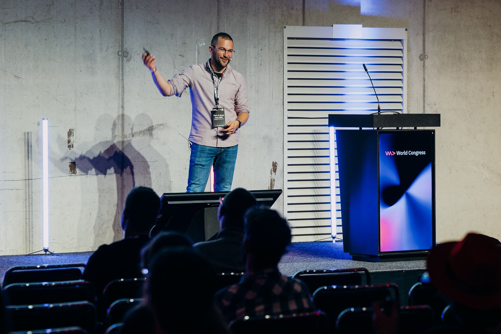 Sasa Fajkovic pointing towards the screen beside the World Congress lectern at WeAreDevelopers World Congress 2026