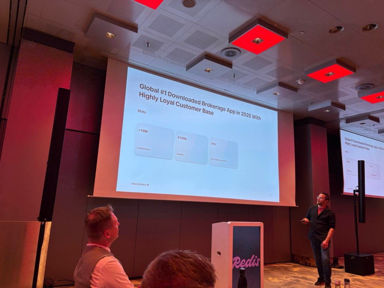Sasa Fajkovic presenting a Trade Republic slide at the Redis AI Roadshow in Munich, with the audience in the foreground
